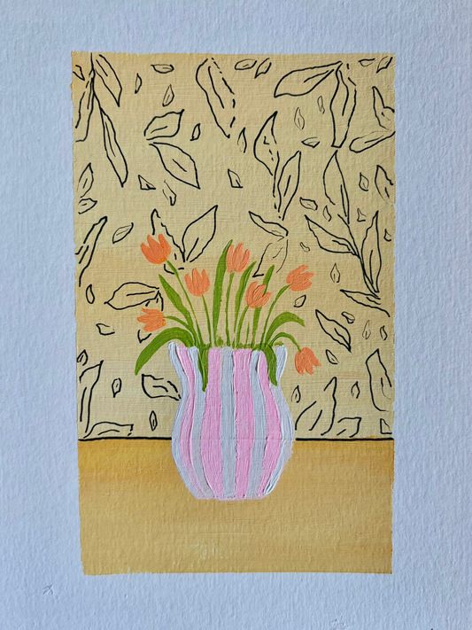Orange tulips in pinstripe vase